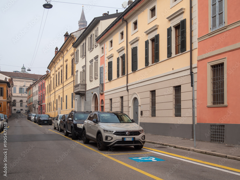 Fototapeta premium Volkswagen T Roc parked on a city street in Italy with historical buildings and a church tower visible in the background