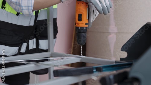 Wallpaper Mural Female workers wearing reflective vests use cordless steel drills to drill steel or aluminum. Torontodigital.ca