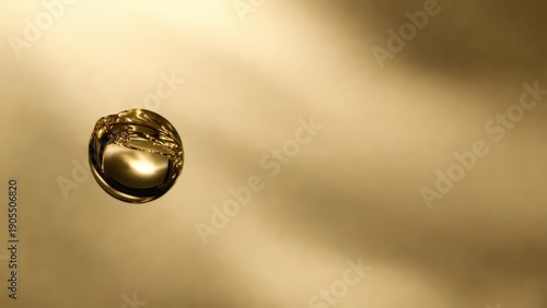 Abstract golden liquid drop floating on soft amber background representing luxury serum or oil