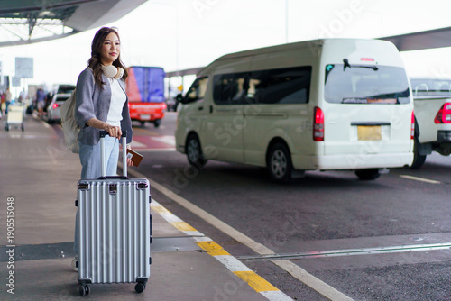 Cuadro en lienzo Asian woman traveler waiting with suitcase at airport pickup area