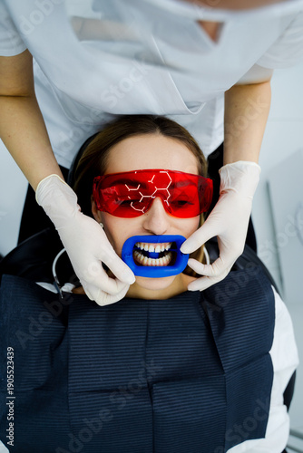 Tableau sur toile Dentist uses cheek retractor to reveal teeth prior to dental whitening treatment