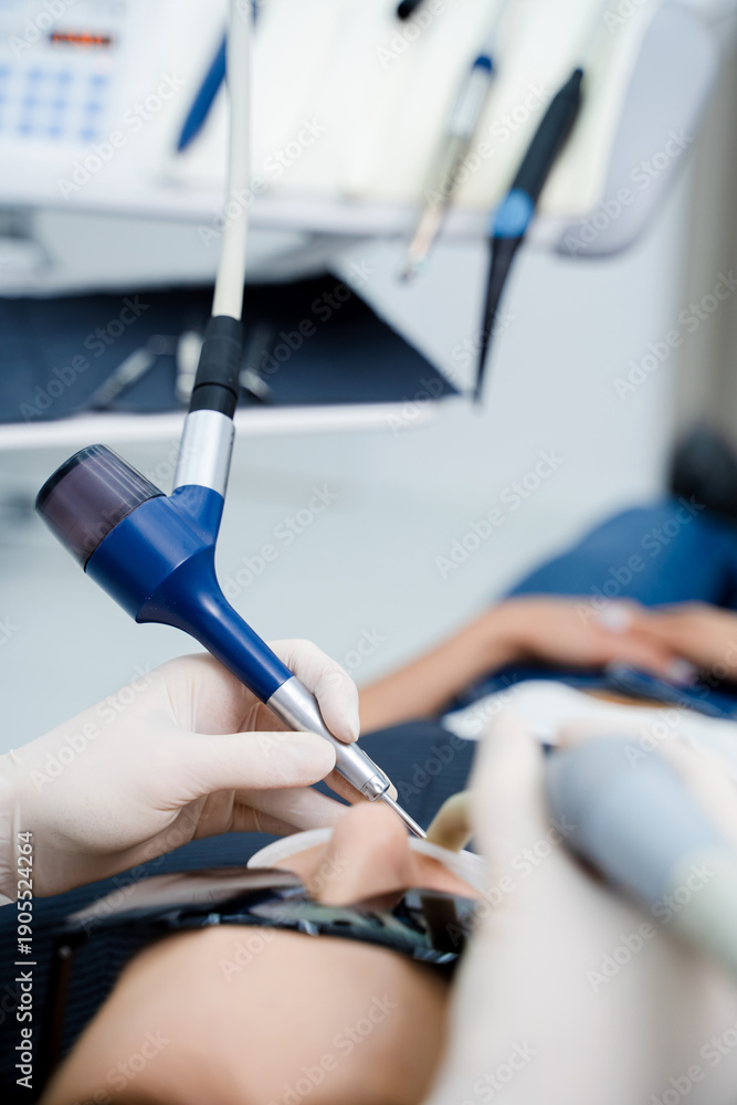 Fototapeta premium Dental cleaning using Air Flow technology to polish teeth and remove plaque.