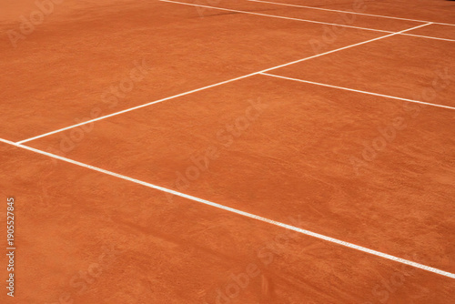 Tennis court surface with white lines and reddish clay texture  