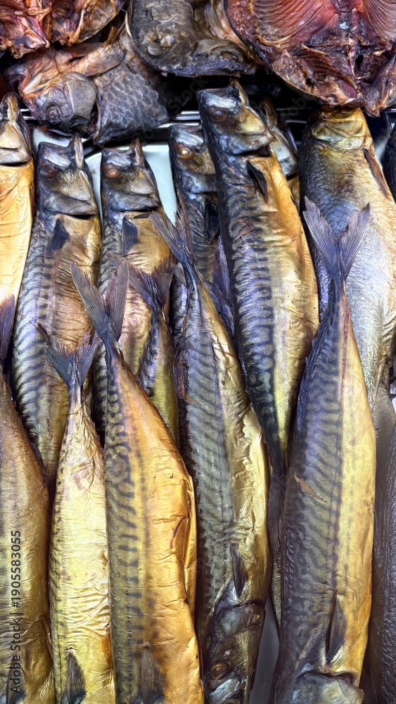 Obraz premium Whole cold smoked mackerel fish displayed on a market shelf 