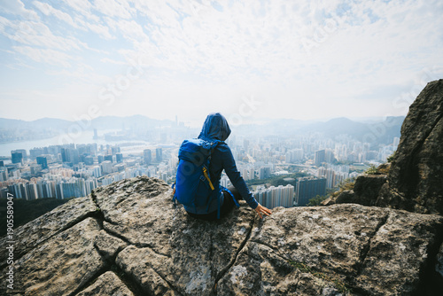 Canvas Print Woman traveller sit on the cliff edge enjoy the beautiful view of hong kong