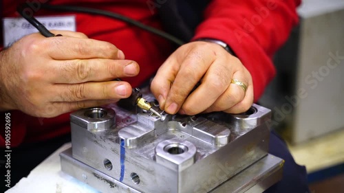 Close-up of a master welder repairing a worn-out plastic injection mold in a factory. Concept of industrial maintenance, engineering precision, and business finance efficiency.