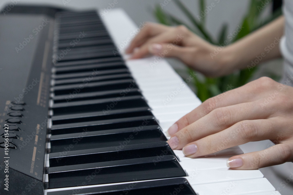 Obraz premium Woman playing digital piano at home for leisure.