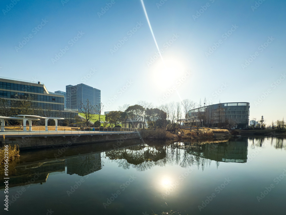 Naklejka premium Peaceful Riverside Scene at Sunrise in Urban Setting