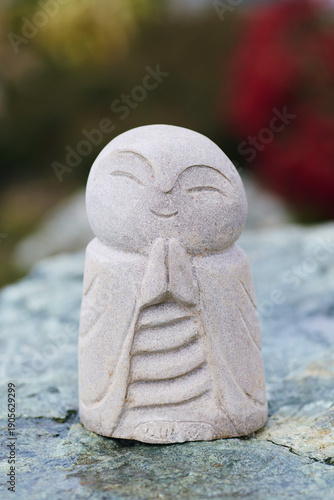 Smiling Stone Monk Statue Praying Hands Namaste Zen Garden Sculpture Close-Up