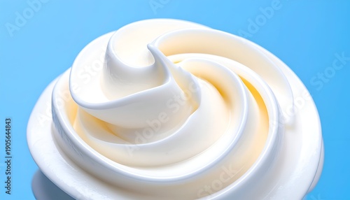 Swirled white soft serve ice cream with a smooth texture on blue background