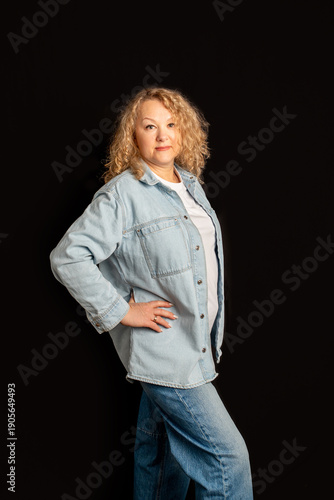 Mature woman in casual denim shirt posing with hand on hip. Successful business owner. Business portrait of designer, businesswoman, successful woman 56 years old