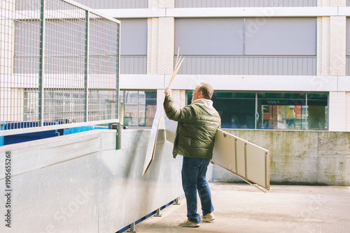 Bilde på lerret Man throws away old furniture at waste disposal center