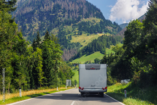 Photography Scenic back view modern white family rv camper van vehicle drive Europe curvy road alpine pass mountain sunny summer day