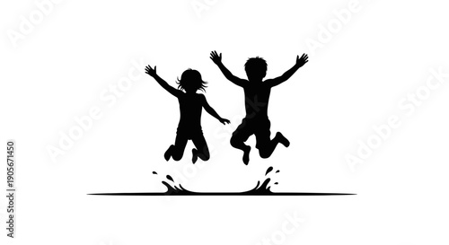 Silhouette of two children jumping and playing together happily.