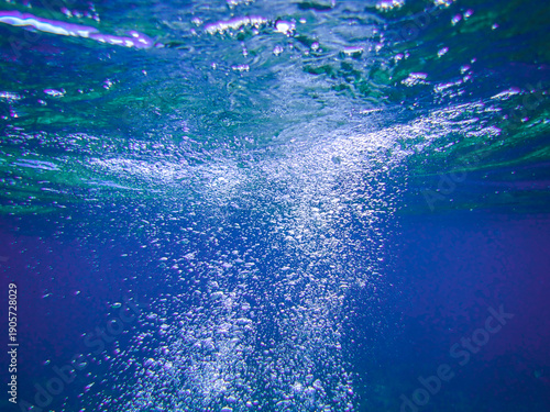 Fotografie Air bubbles underwater rising to water surface, natural scene, bubbles under water, bubble undersea, sea in crystal clear green water