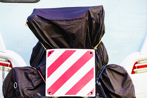 Camper with bicycle on back rack. Bike protected by protective cover tarpaulin.