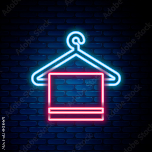 Glowing neon line Towel on a hanger icon isolated on brick wall background. Bathroom towel icon. Colorful outline concept. Vector