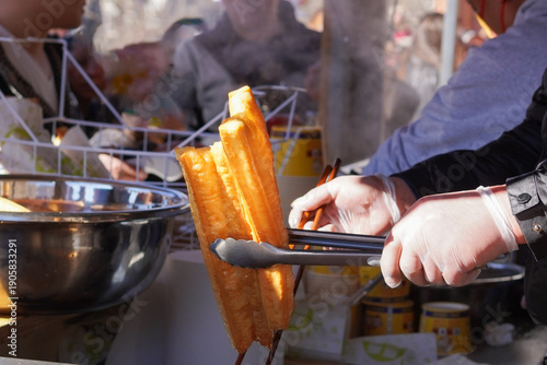 Youtiao, Traditional Chinese fried dough sticks being fried at a street stall