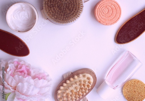 Bath and spa products and a pink peony on a light pink background. Layout - top view.
