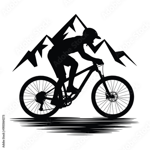 Silhouette of a mountain biker riding uphill against a mountain backdrop