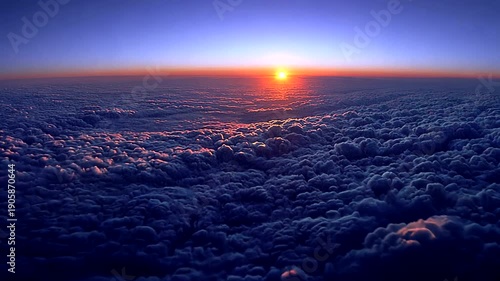 Aerial view of a vast cloudscape bathed in the warm glow of a setting sun