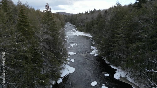 Low aerial flight over snowy river in Blackwater Falls State Park