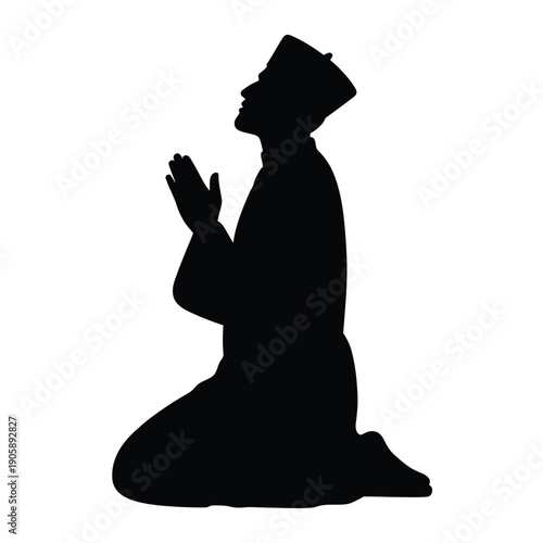 Silhouette of a man kneeling in prayer hands raised upwards