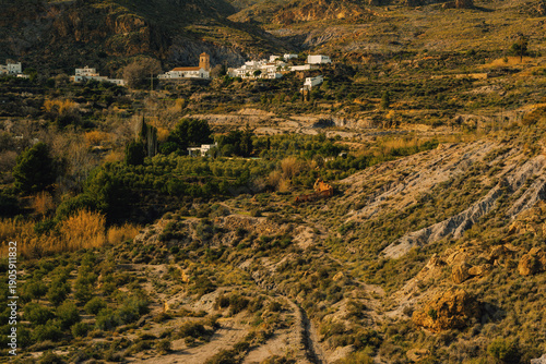 The Spanish village of Huebro on a steep slope surrounded by rough steep rocky mountains. Huebro, Almeria, Andalusia, Spain.