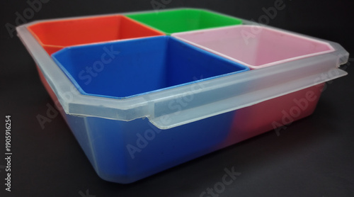 storage box contains four compartments with different colors, black background