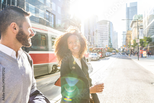 Happy diverse couple walking urban city street in morning sun