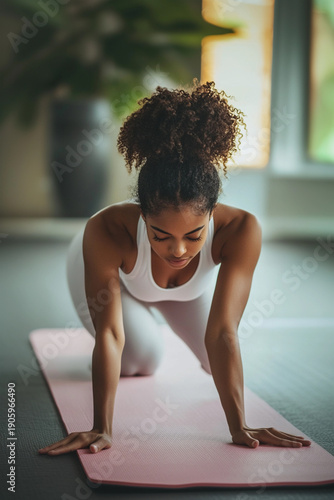 Young African American Woman Practicing Yoga on a Pink Mat Indoors