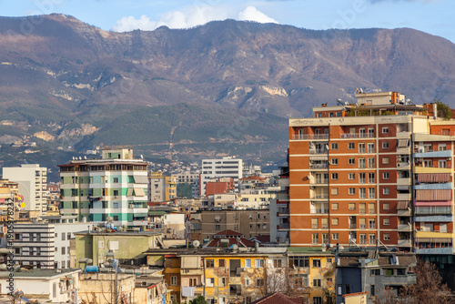 Residential apartment buildings and dense urban housing with mountains in background during daylight in capital city Tirana, Albania