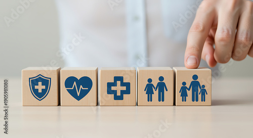 Hand selecting wooden blocks with health and family protection icons, representing comprehensive insurance and wellness concept