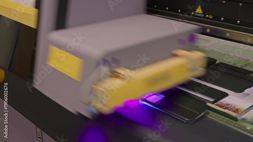 4K footage of a UV printer simultaneously printing an image on ten mobile phone cases in an automated production line.