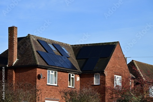 Tableau sur toile Red brick house roof with multiple residential solar panels in UK
