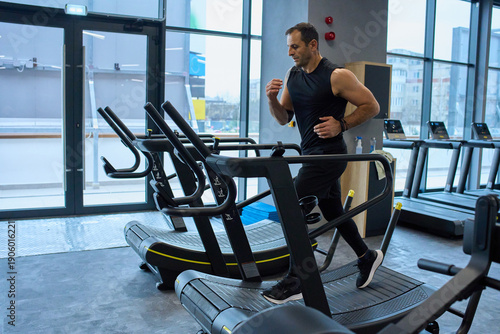 Man running on curved treadmill at gym