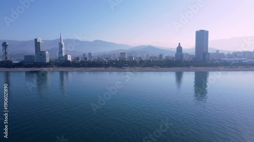 Slow drone aerial over Batumi in warm autumn morning, showing calm sea and city skyline. Minimalist 4K footage with peaceful travel mood.