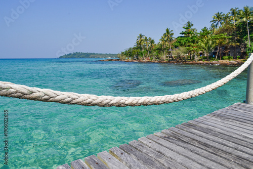 kho kood thailand, beack with palm and resort in turquise sea wooden dock