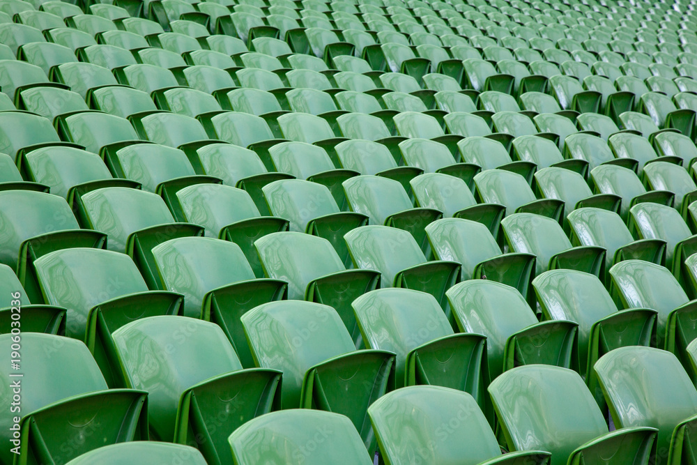 Fototapeta premium Rows of empty green plastic seats in a sports stadium