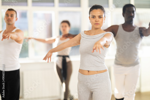 Fotografie Concentrated women and men rehearsing ballet dance in studio