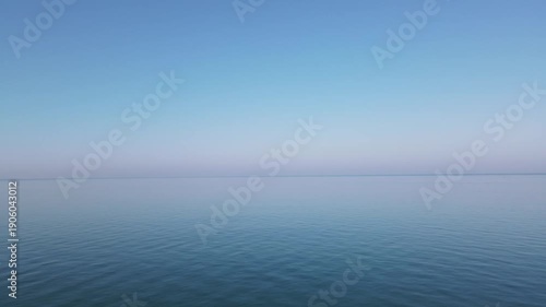 Drone view of calm blue sea with pink sunset horizon in Batumi Georgia. Romantic autumn atmosphere, minimal 4K aerial footage.