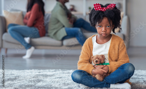 Foto A young girl sits on the floor holding a teddy bear