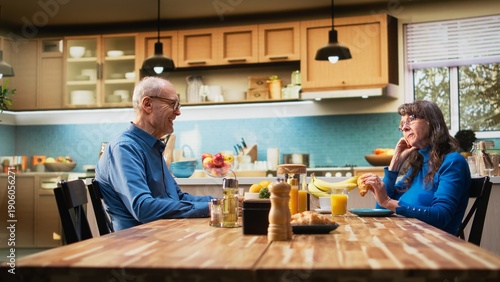 Quadro su tela Senior wife looking exasperated and disengaged as husband continues talking, strained morning routine shows displeasure and monotony in domestic retired life together