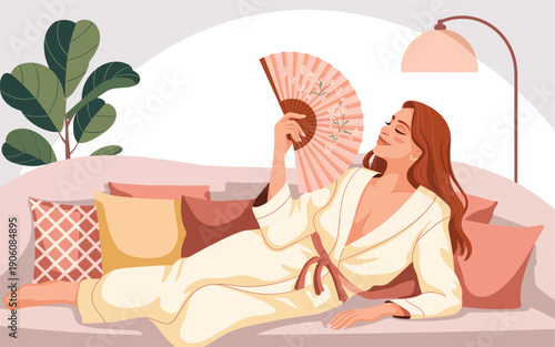 Woman relaxing on a couch with a fan, enjoying a serene atmosphere indoors