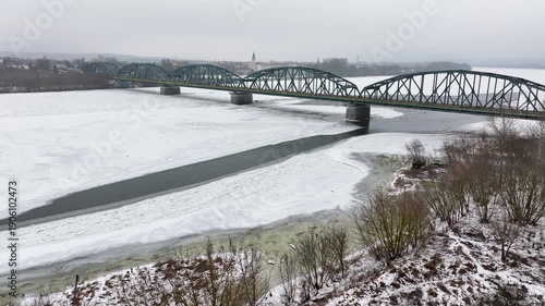 Aerial Vistula River ice winter Fordon bridge Poland 1 4K. Winter season cold arctic temperatures, ice flows, dangerous ice jams damage waterway. Longest river Poland. From Baltic Sea. 