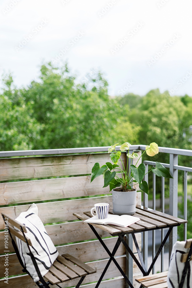 Obraz premium Cozy balcony with small table and plant for enjoying coffee and relaxation time