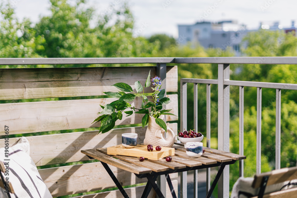 Obraz premium Balcony setup for breakfast with view of green trees and urban landscape