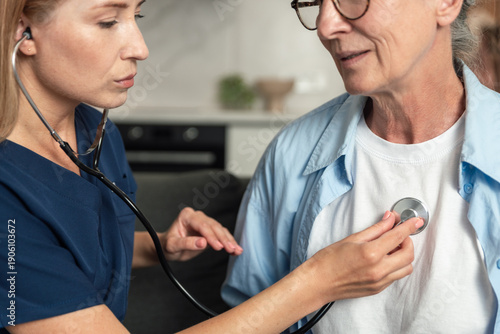 Tableau sur toile Doctor checks heartbeat of elderly woman during home healthcare visit