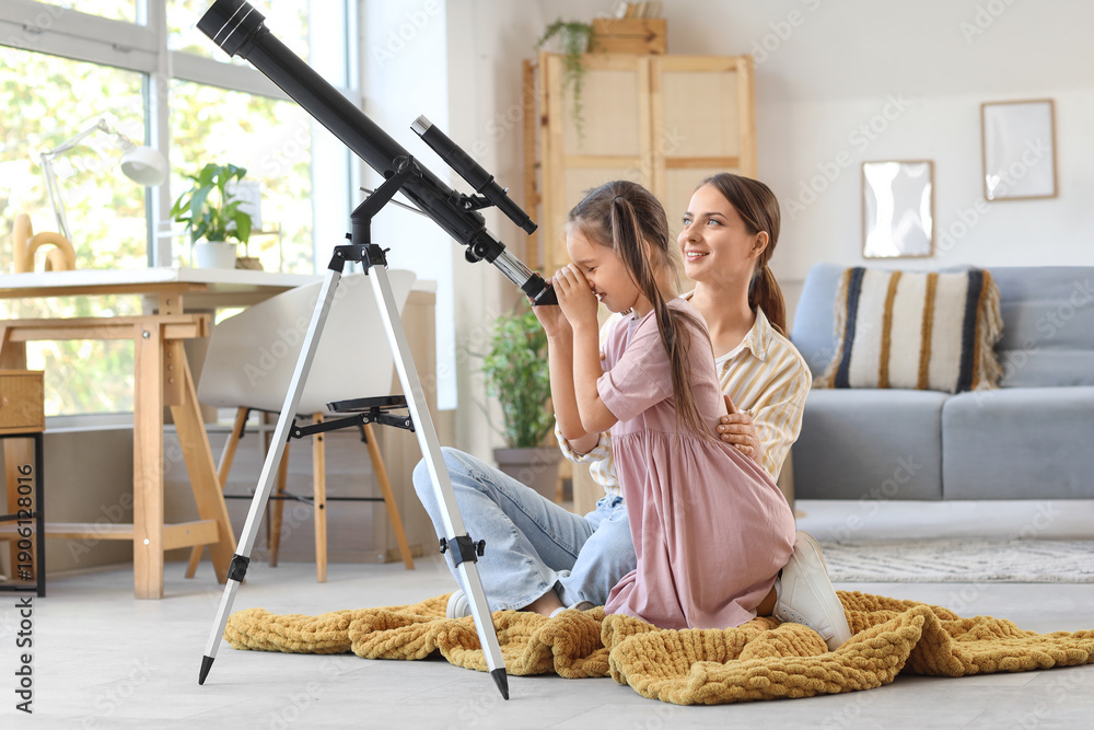 Fototapeta premium Little girl with her mother looking through telescope at home