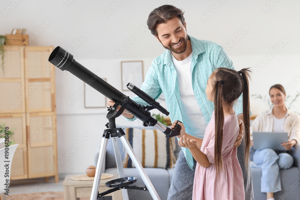 Fototapeta premium Little girl with her father and telescope at home